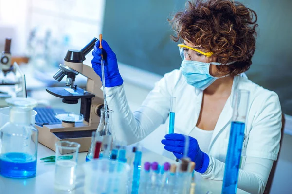 Joven científica en gafas protectoras y guantes preparan un — Foto de Stock