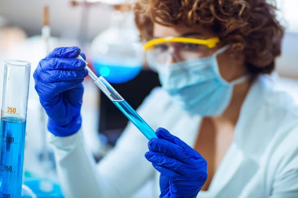 Joven científica en gafas protectoras y guantes cayendo — Foto de Stock