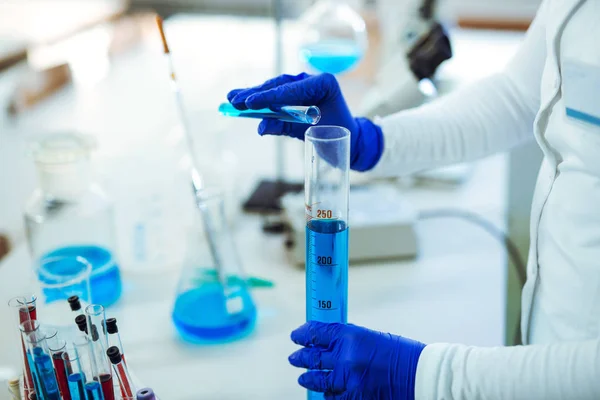 Ženské vědec pomocí zkumavky s modrou kapalných vzorků látek — Stock fotografie