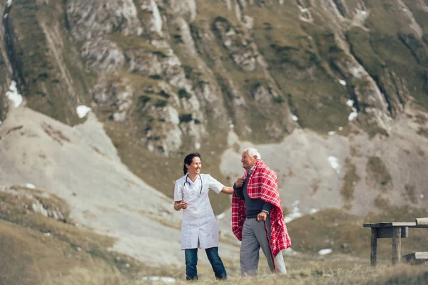 Медсестра помогает старшим ходить — стоковое фото