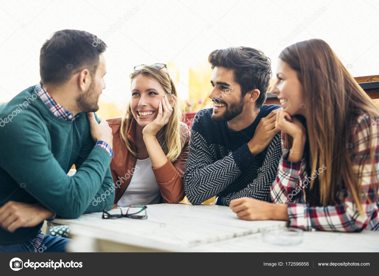 Group of four friends having fun a coffee together. Two women an ...