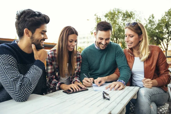 Grupo de cuatro amigos divirtiéndose tomando un café juntos. Dos mujeres un — Foto de Stock