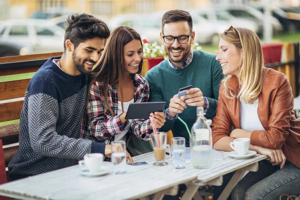 Gruppe på fire venner har det sjovt en kaffe sammen efter shopping - Stock-foto