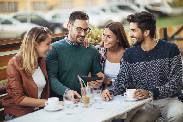Grupo de cuatro amigos divirtiéndose tomando un café juntos. Dos mujeres un —  Fotos de Stock