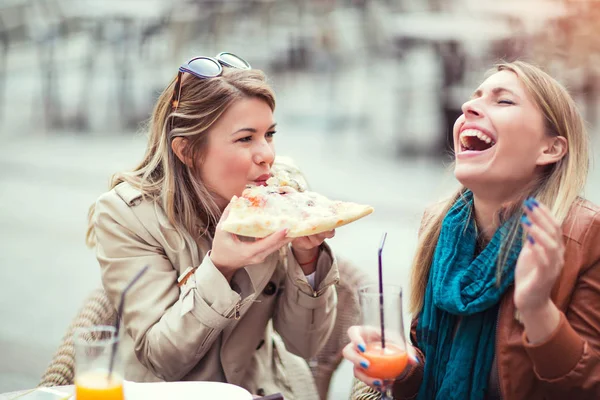 Jonge vrouwen die eten van pizza — Stockfoto