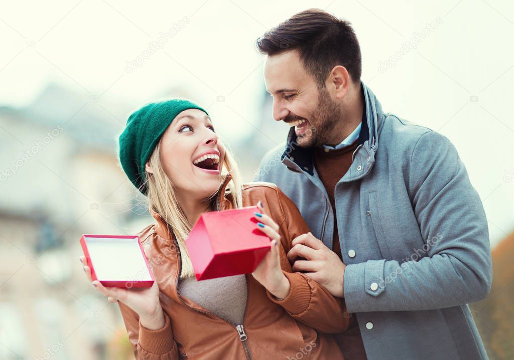 Man surprising girlfriend with gift.