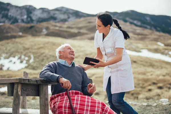 Vårdaren sjuksköterska och senior manlig patient — Stockfoto