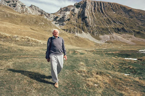 Senior man op bergen weg — Stockfoto