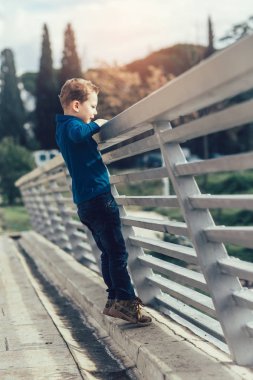 Köprü korkuluk üzerine eğilerek çocuk