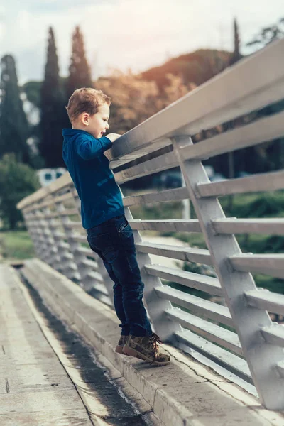 Köprü korkuluk üzerine eğilerek çocuk