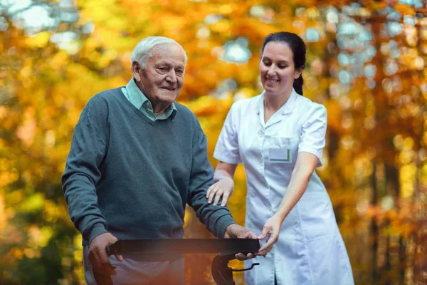 Enfermera ayudando a anciano — Foto de Stock