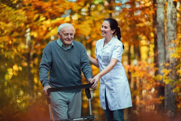 Enfermera ayudando a anciano — Foto de Stock