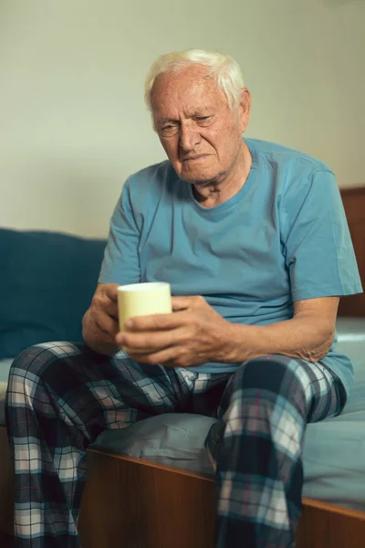 Idősebb ember ül ágyas — Stock Fotó