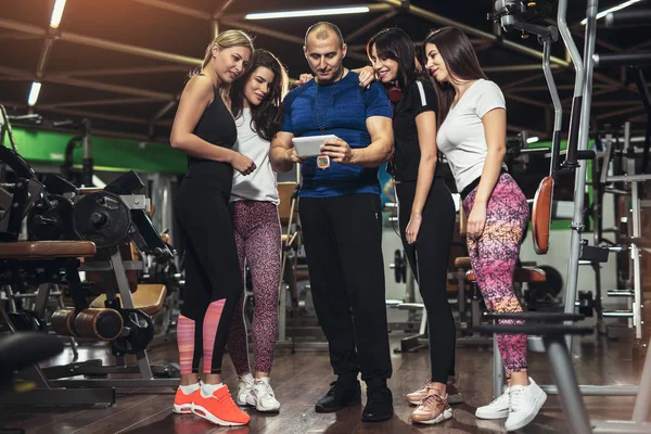 Bonito Personal Trainer Usando Tablet Digital Grupo Mulheres Desportivas Torno — Fotografia de Stock