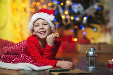 kırmızı şapka Noel Baba'ya mektup yazma küçük mutlu çocuk 
