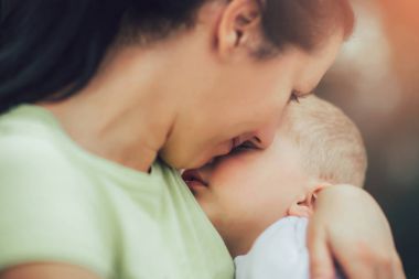 mutlu annesinin kollarında uyuyan sevimli küçük çocuk 