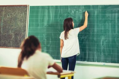 blackboard ile tebeşir, masada oturan başka bir kız yazma zeki şirin kız öğrenci
