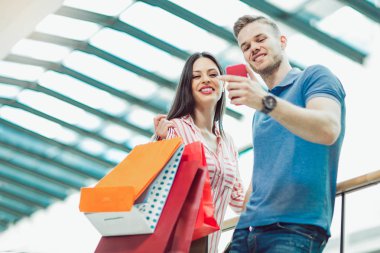 alışveriş torbaları ve selfie alışveriş merkezinde konuşmak smartphone ile mutlu genç Çift
