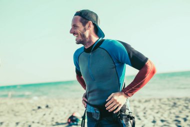 aktif erkek kitesurfer kum plajındaki gülümseyen portresi