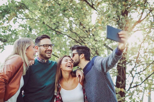 Grup genç mutlu arkadaşlar Bahar park dijital tablet ve alma selfie ile eğleniyor 
