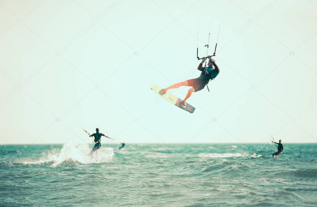 active man kitesurfing among sea waves 