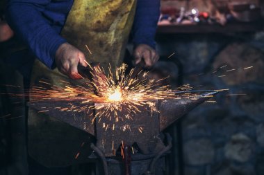 El ile smithy kıvılcım havai fişek ile örs üzerinde erimiş metal dövme demirci yakın çekim