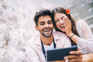 Merdivenlerde oturan ve tablet bilgisayar başında arıyor Romantik Çift