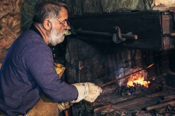 Senior Schmied Schmiedet Eisen Bei Der Arbeit — Stockfoto