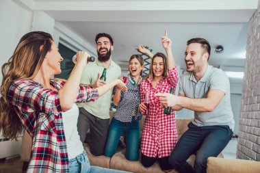 Evde karaoke yapan bir grup arkadaş. Arkadaşlık kavramı, ev eğlencesi ve insanlar