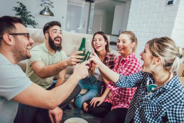 Bir grup mutlu genç arkadaş evde bira içip eğleniyorlar.