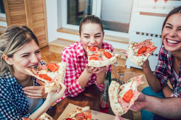 Pizza yiyen bir grup genç arkadaş. Ev partisi. Fast food konsepti..