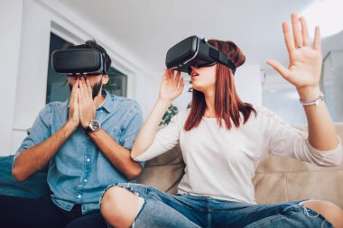 Genç erkek ve kadın sanal gerçeklik gözlük izlemek ve gösterilen rahat kıyafetler giymek Vr kamera, teknoloji ve İnovasyon kavramı düşünün