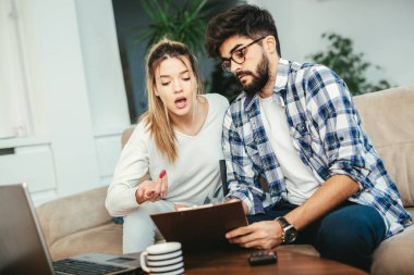 Kadın ve erkek birlikte evrak işi yapıyor, vergilerini internet üzerinden ödüyor.
