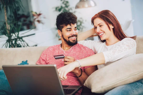 Щаслива Міжрасова Пара Купує Онлайн Вдома Використовуючи Кредитну Картку Сміючись — стокове фото