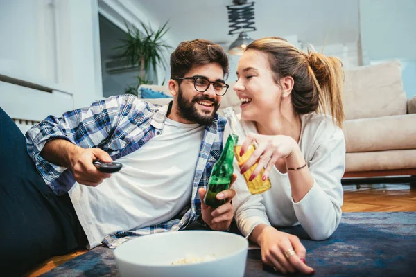 ビールを飲みながら テレビを見て楽しんでいる愛のカップル — ストック写真