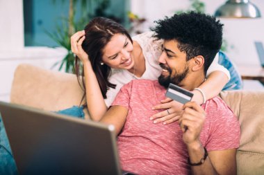 Evde alışveriş online, kredi kartı ile gülerek mutlu ırklararası çift