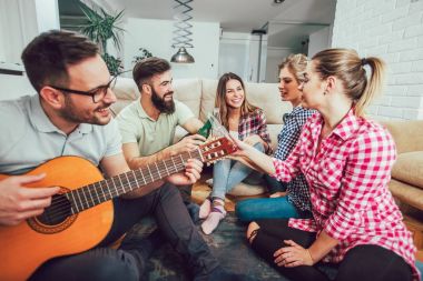 Bir grup mutlu genç arkadaş evde bira içip eğleniyorlar.