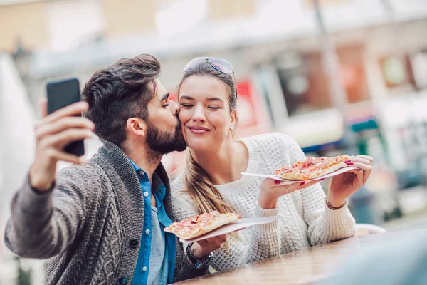 情侣在户外吃披萨小吃 他们分享比萨饼和吃 使自拍照片 — 图库照片