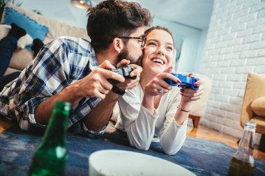 Mutlu genç çift eğleniyor evde videogames oynarken