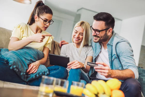 Duas Mulheres Homem Sala Estar Com Cartão Crédito Tablet Digital — Fotografia de Stock