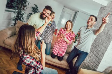 Evde karaoke yapan bir grup arkadaş. Arkadaşlık kavramı, ev eğlencesi ve insanlar