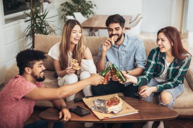 Pizza yiyen bir grup genç arkadaş. Ev partisi. Fast food konsepti..