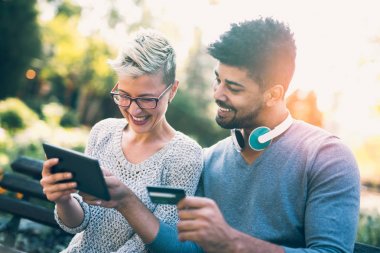 Güzel genç karışık yarış çift dijital tablet gülümseyen kullanma online alışveriş yapıyor