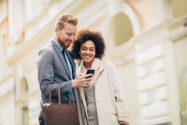 Akıllı telefon açık havada kullanarak mutlu iş Çift