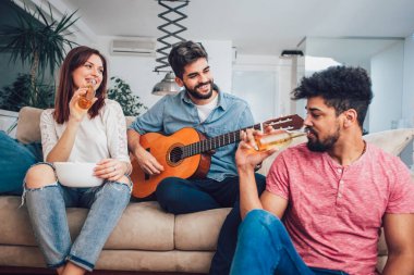 Bir grup mutlu genç arkadaş evde bira içip eğleniyorlar.