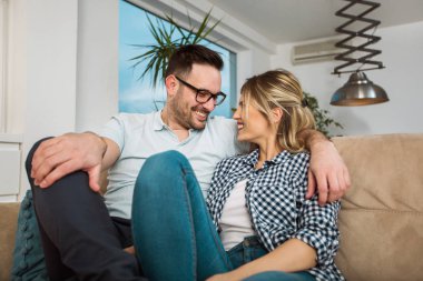 Sevgi dolu genç bir çift evdeki kanepede sarılıp dinleniyorlar.