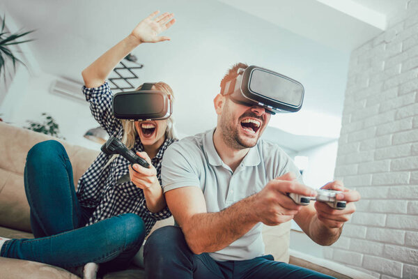 Счастливые друзья, играющие в видеоигры с очками виртуальной реальности - Молодые люди, получающие удовольствие от новых технологий консоли онлайн
