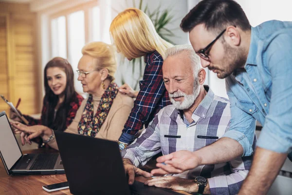 Young volunteers help senior people on the computer. Young peopl — Stock Photo, Image