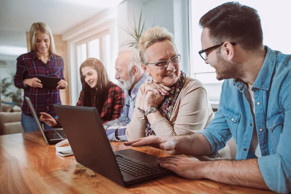 Junge Freiwillige helfen Senioren am Computer. junge Menschen — Stockfoto