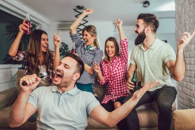Evde karaoke oynayan arkadaş grubu. Kavram friendsh hakkında